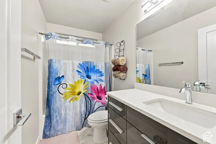 Vanity featuring a single undermount sink, a chrome faucet, and dark wood-finish cabinetry with silver-tone hardware