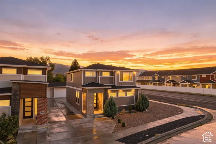 Modern exterior with clean lines, mixed material facade, concrete driveway, and front landscaping