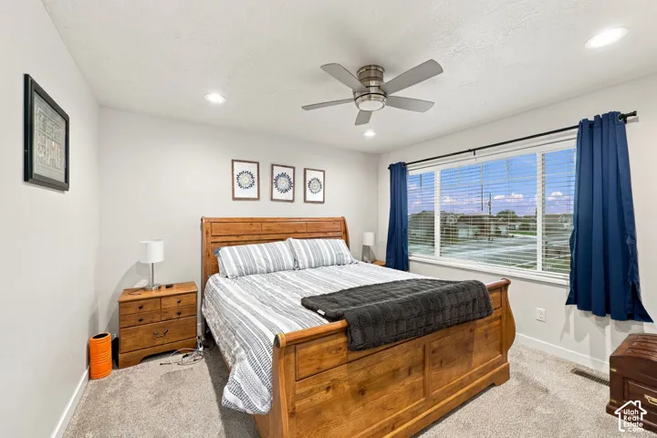 Recessed lighting, ceiling fan, large window, and carpeted flooring