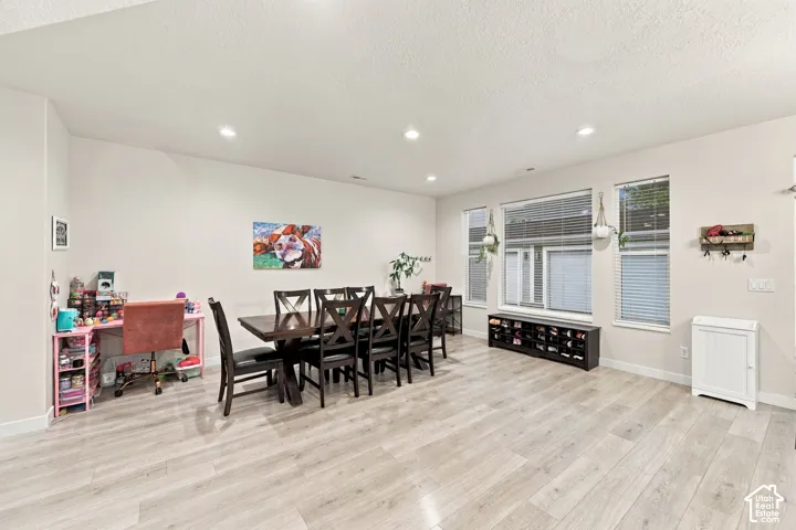 Recessed lighting, wood-finish flooring, and multiple windows with blinds