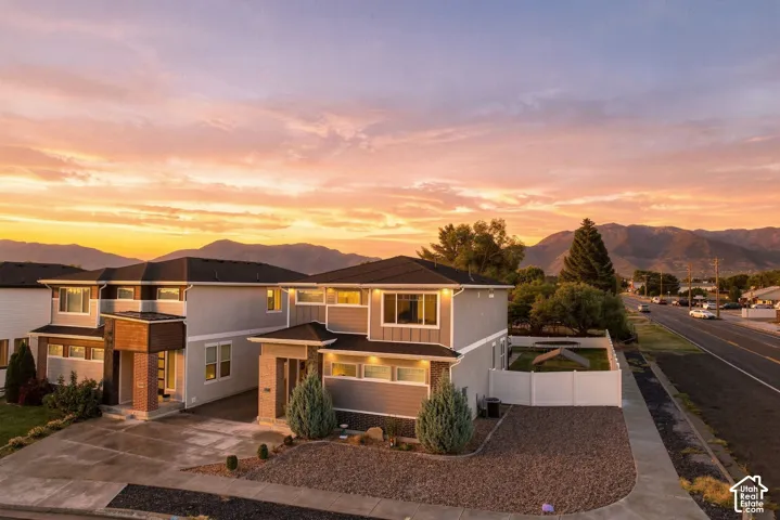 Contemporary exterior with varied siding, an attached garage, and a gravel driveway