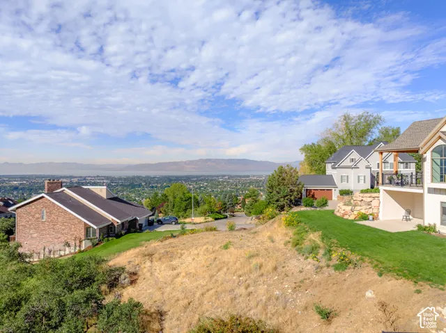 Expansive property with a large lawn area, mature landscaping, and an outdoor patio space