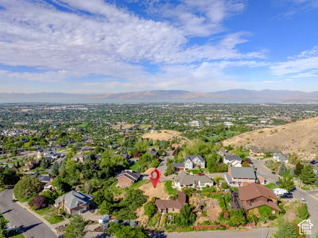 Aerial perspective of a developed residential area with distant mountains and a body of water