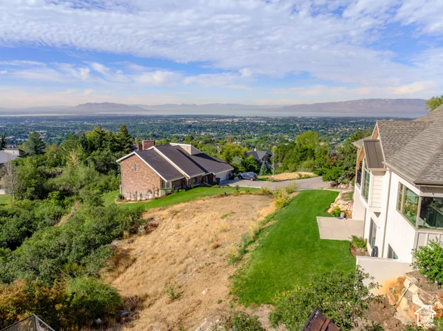 Expansive terraced lot featuring a manicured lawn, established landscaping, and a concrete patio