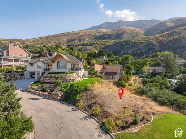 Architectural residence featuring a multi-level design with extensive rock retaining walls and a paved driveway