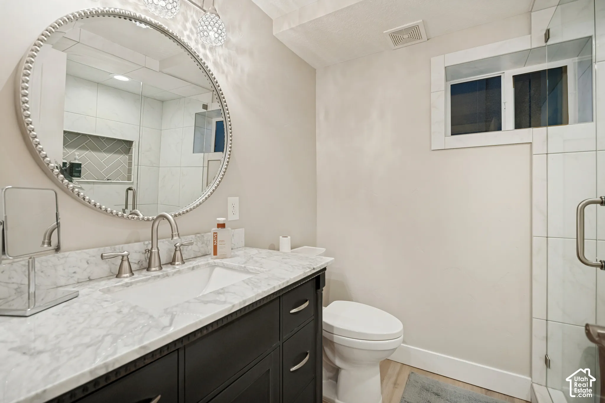 Vanity with a stone countertop, undermount sink, and brushed nickel faucet