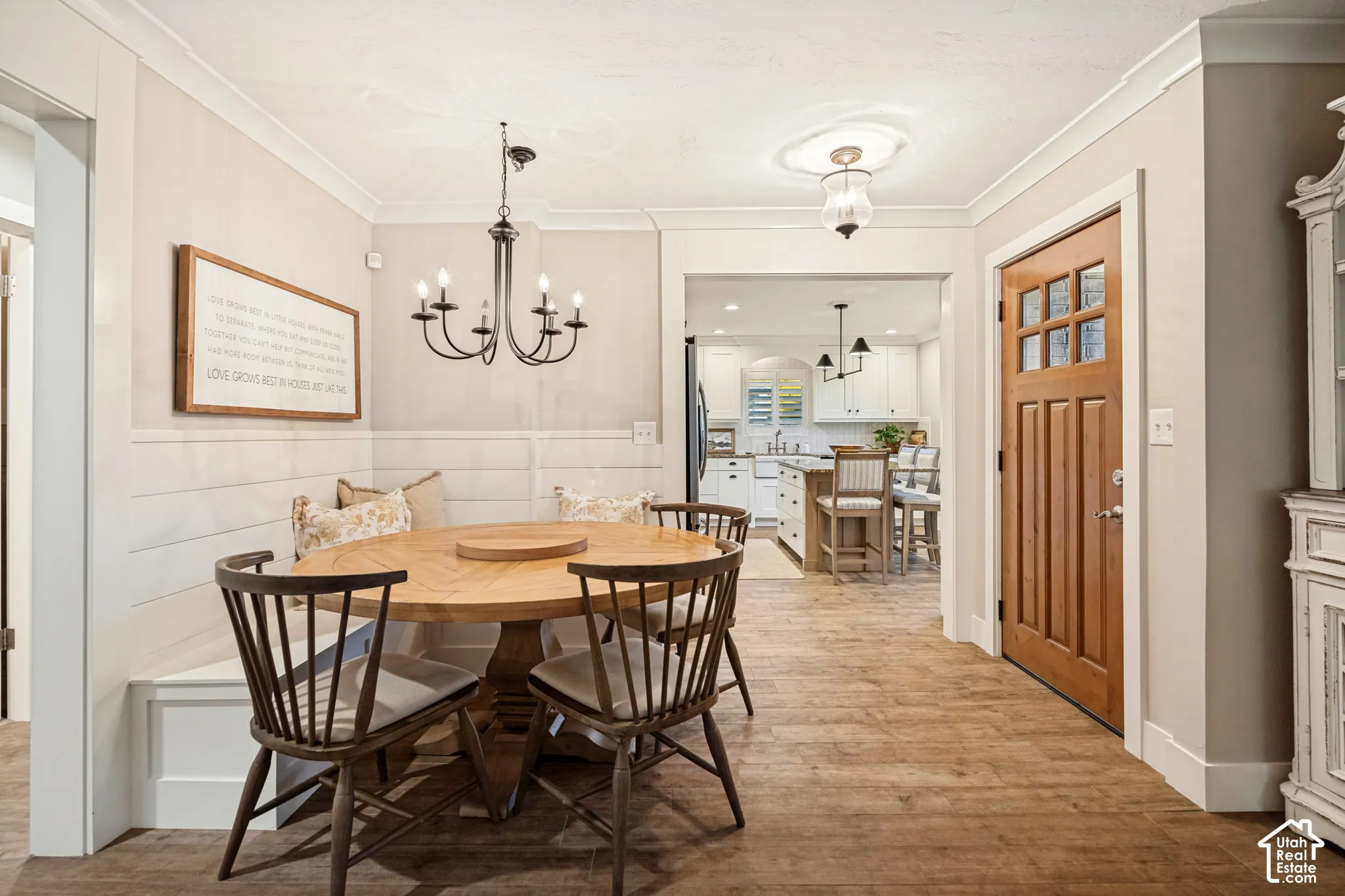 Elegant dining area featuring a round wood-finish table, windsor-style chairs, and hardwood flooring