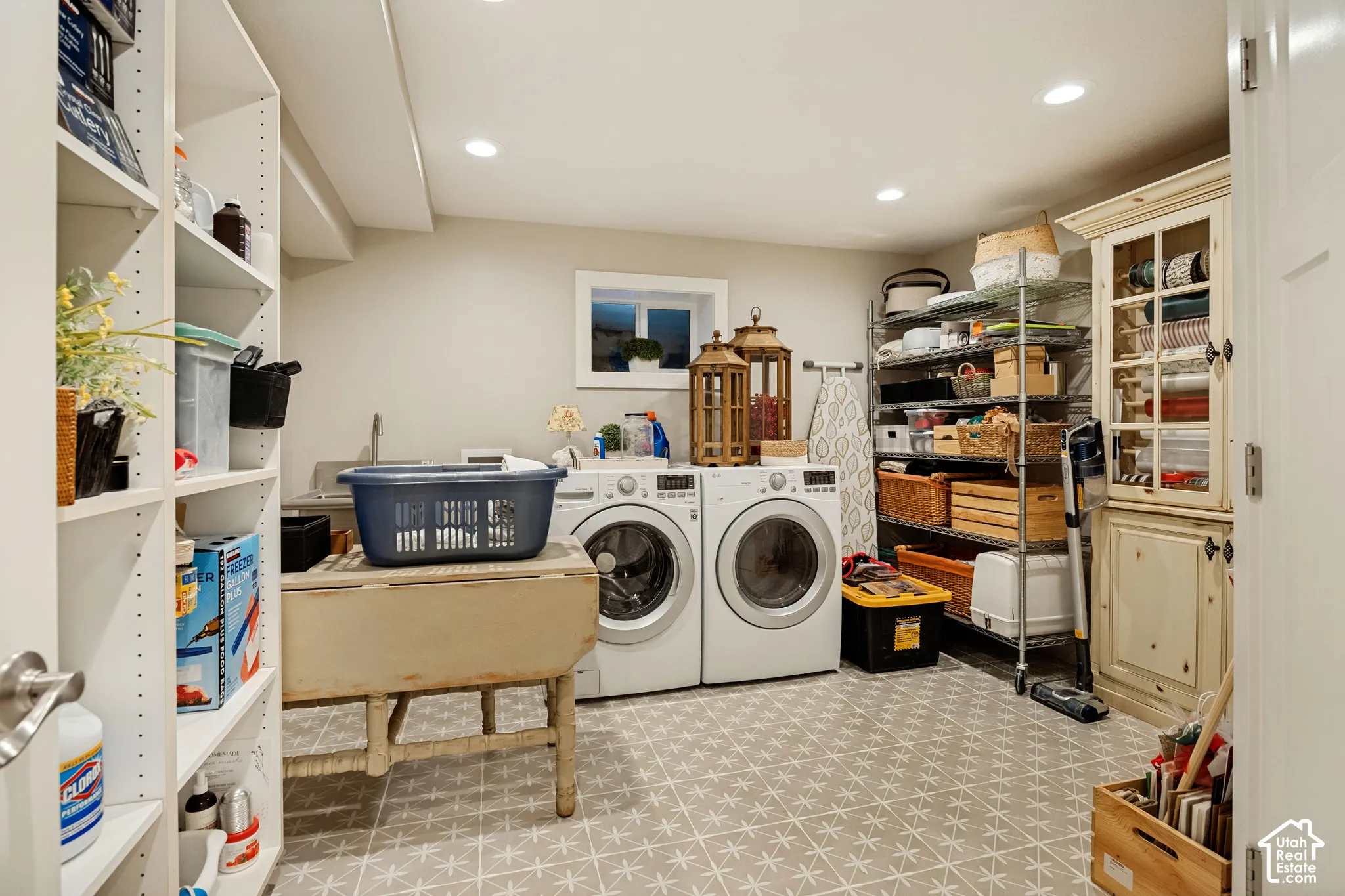 Laundry area with patterned flooring, built-in shelving, and a utility sink