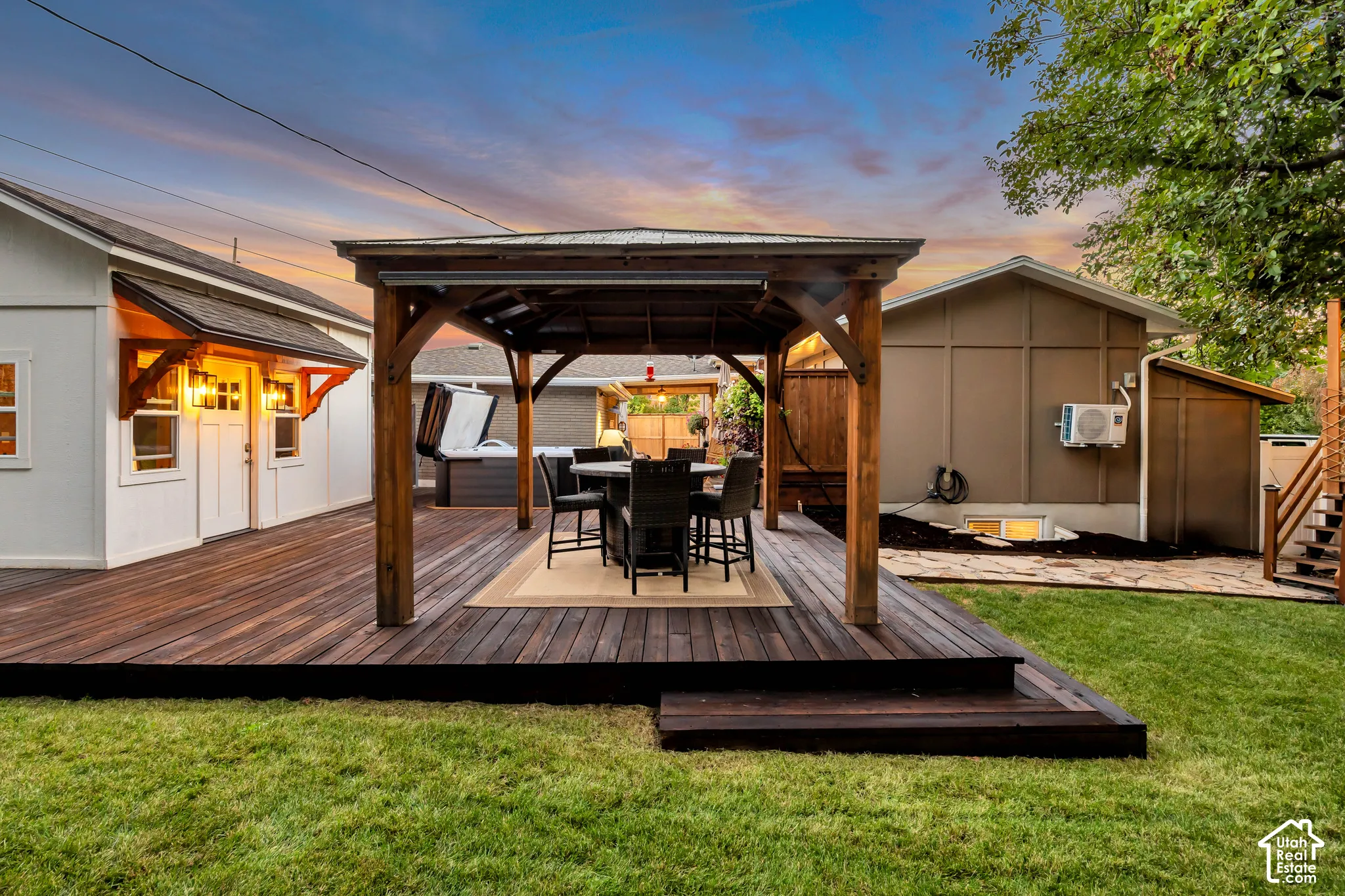 Expansive wood-finish deck with built-in steps, featuring a covered outdoor dining area