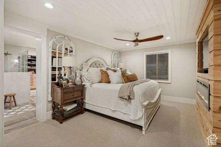 Shiplap ceiling with recessed lighting, wood-finish ceiling fan, integrated wall-mounted fireplace, window with blinds, and light-toned carpeting