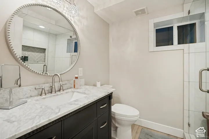 Vanity with a stone countertop, undermount sink, and brushed nickel faucet