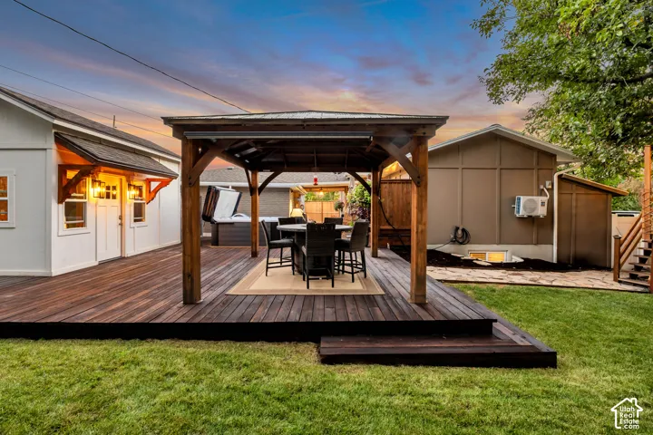 Expansive wood-finish deck with built-in steps, featuring a covered outdoor dining area