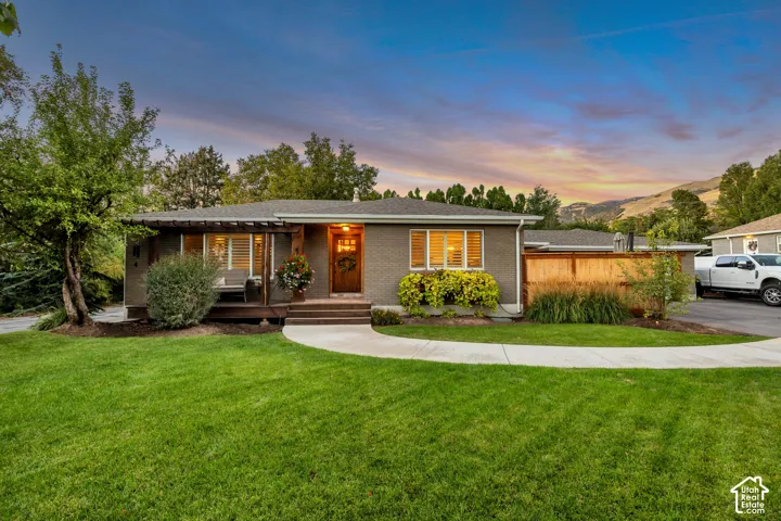Siding exterior, front porch with wood columns, natural wood privacy fence, and concrete walkway
