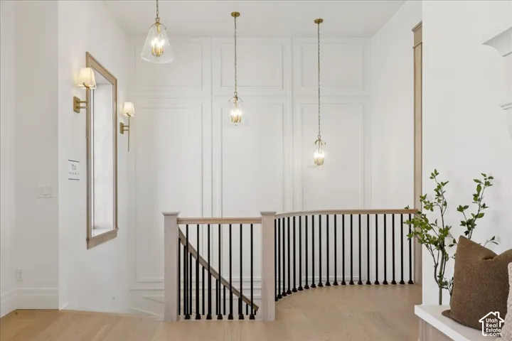 Light wood-finish flooring with a curved staircase featuring black balusters and a light wood handrail