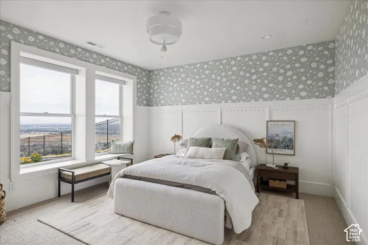 Floor-to-ceiling windows with a built-in window bench, patterned wallpaper, wainscoting, and a ceiling-mounted light fixture
