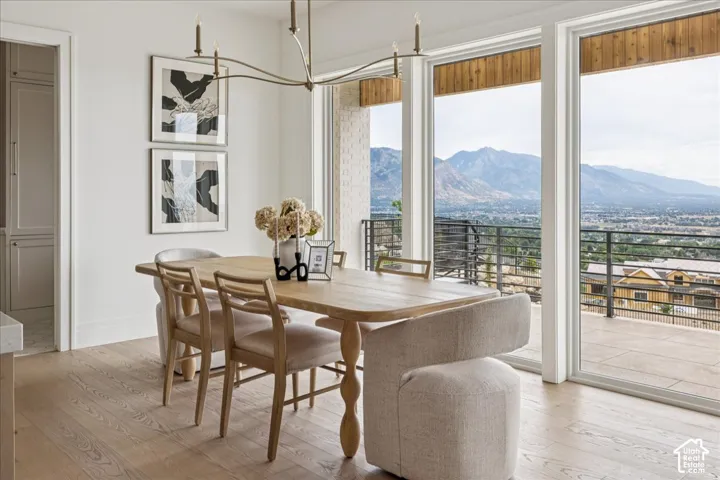 Expansive sliding glass doors, brass-finish chandelier, wood-finish flooring, custom built-in cabinetry, mountain scenery