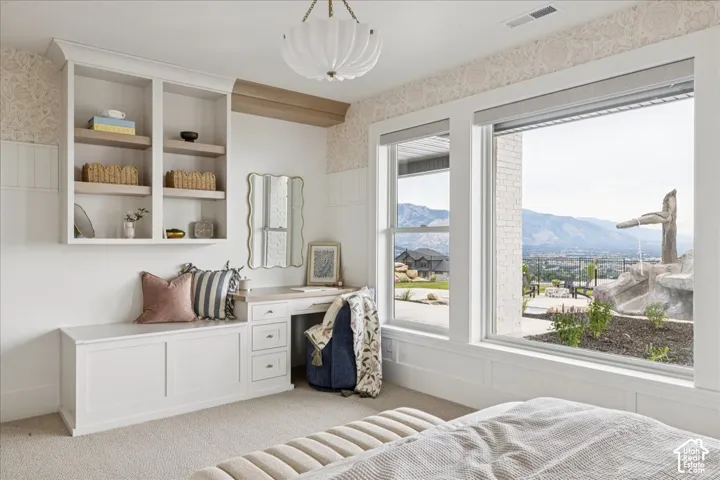 Built-in cabinetry with open shelving, integrated desk, and window bench seating
