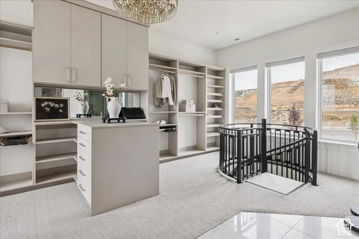 Custom built-in closet system with extensive shelving, central island with drawer storage, and integrated mirrored accents