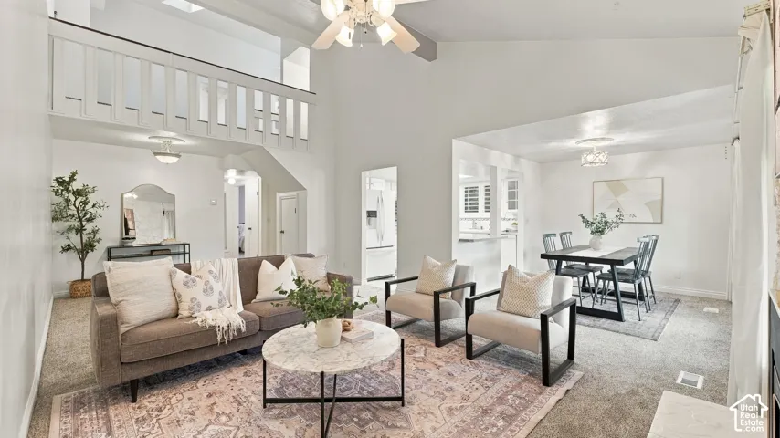 Vaulted ceilings with exposed beams, an open-concept layout, a visible dining area, and a kitchen pass-through window