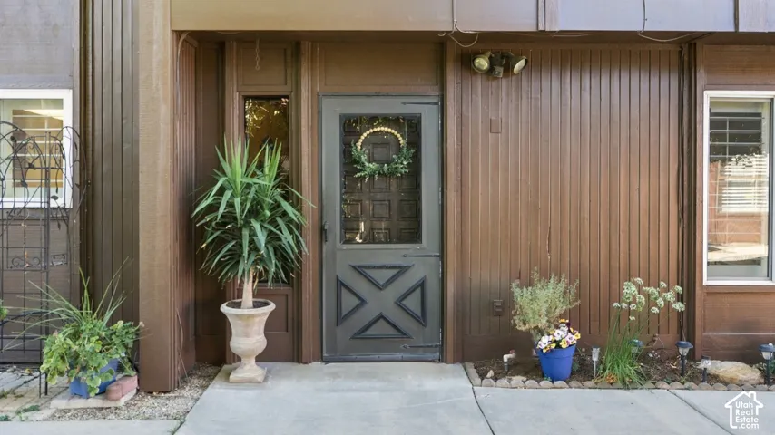 Exterior entry with vertical wood paneling and a dark-framed glass paneled door