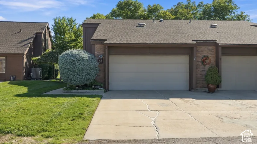 Attached two-car garage with a paved driveway and brick facade