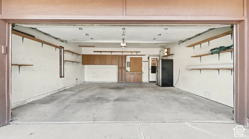 Attached shelving, built-in cabinetry, and concrete flooring