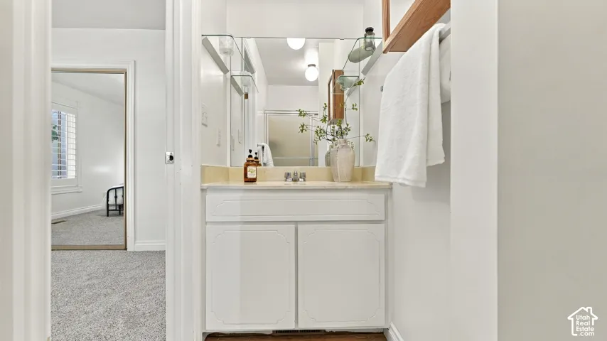 Vanity with a light-toned countertop, undermount sink, and integrated storage cabinet