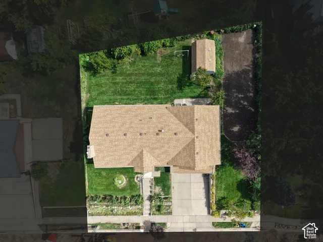 Spacious property featuring a central residence with a gabled roof, expansive green lawn, and an additional outbuilding