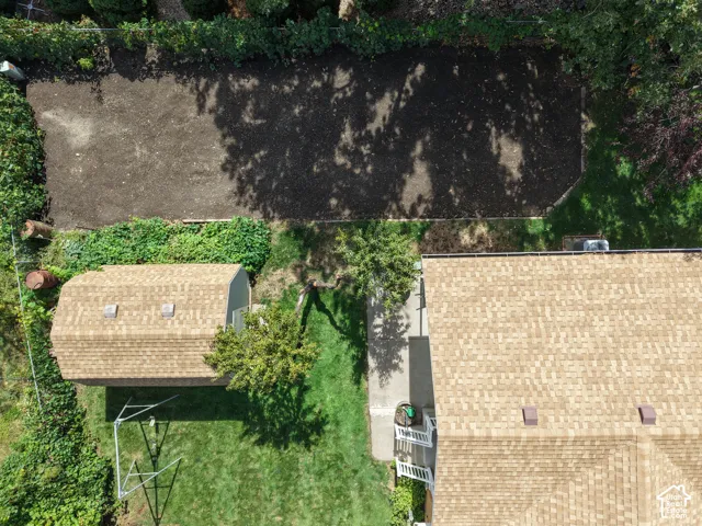 Expansive property featuring a detached outbuilding with a shingle roof and a concrete pathway