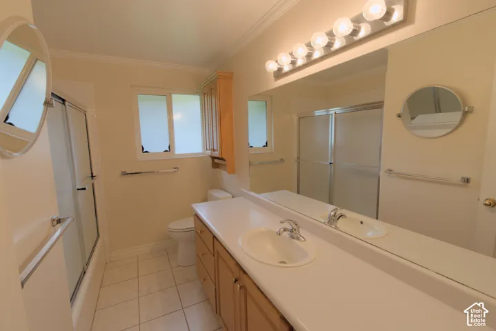 Bathroom featuring a light wood-finish vanity with a white countertop and integrated sink, a full-width wall mirror, a six-bulb vanity light fixture, and a window with frosted panes