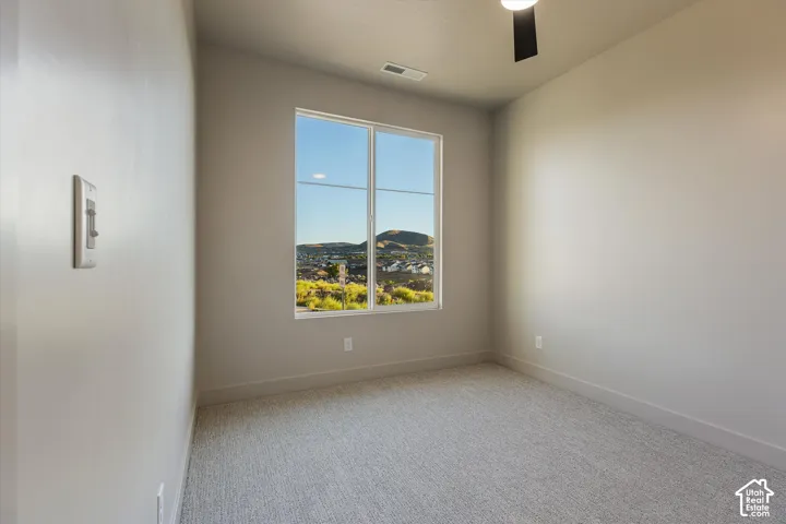 Window offering an expansive mountain backdrop, neutral wall tones, and textured carpeting