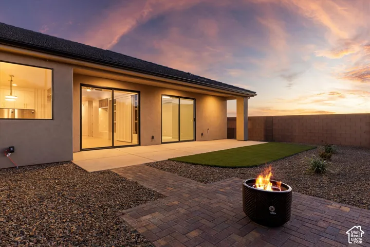 Expansive backyard featuring a paver patio, gravel landscaping, and artificial turf
