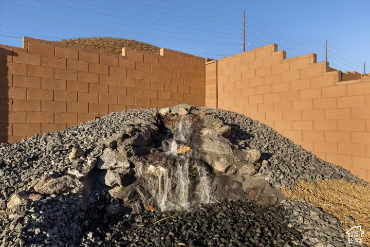 Rock water feature with active waterfall, surrounded by varied gravel landscaping