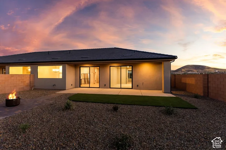 Exterior featuring a dark tile roof and stucco siding