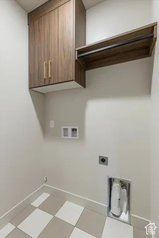Wood-finish cabinetry with brass-toned hardware, an integrated hanging rod, and checkerboard tile flooring