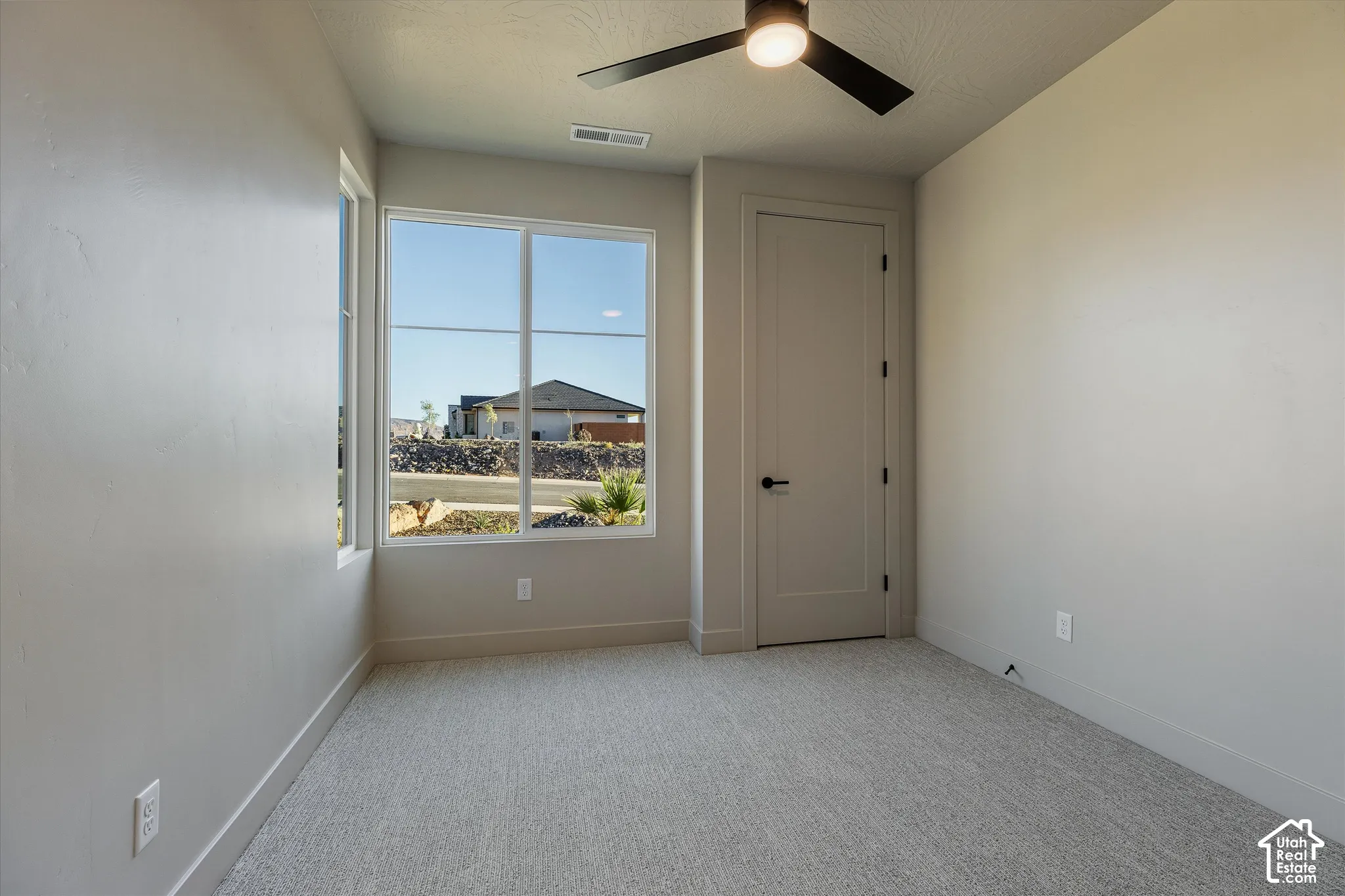 Neutral wall finishes, recessed lighting, and a modern ceiling fan