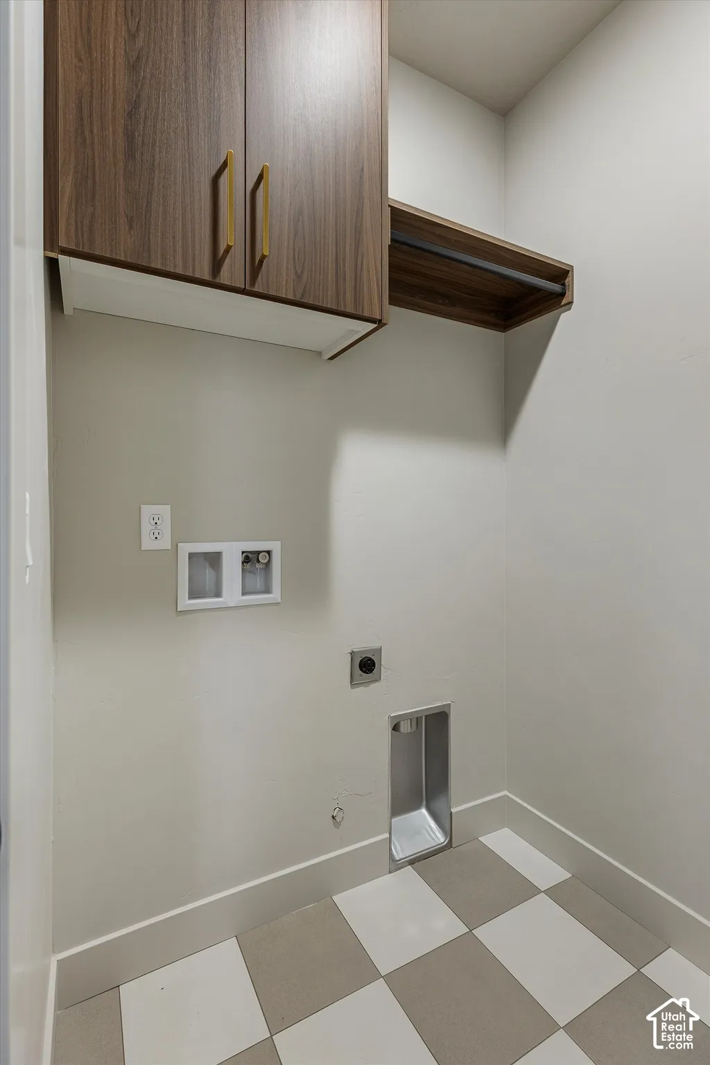 Built-in cabinetry with gold-tone hardware, a wood-finish hanging rod, checkerboard flooring, and light-toned walls