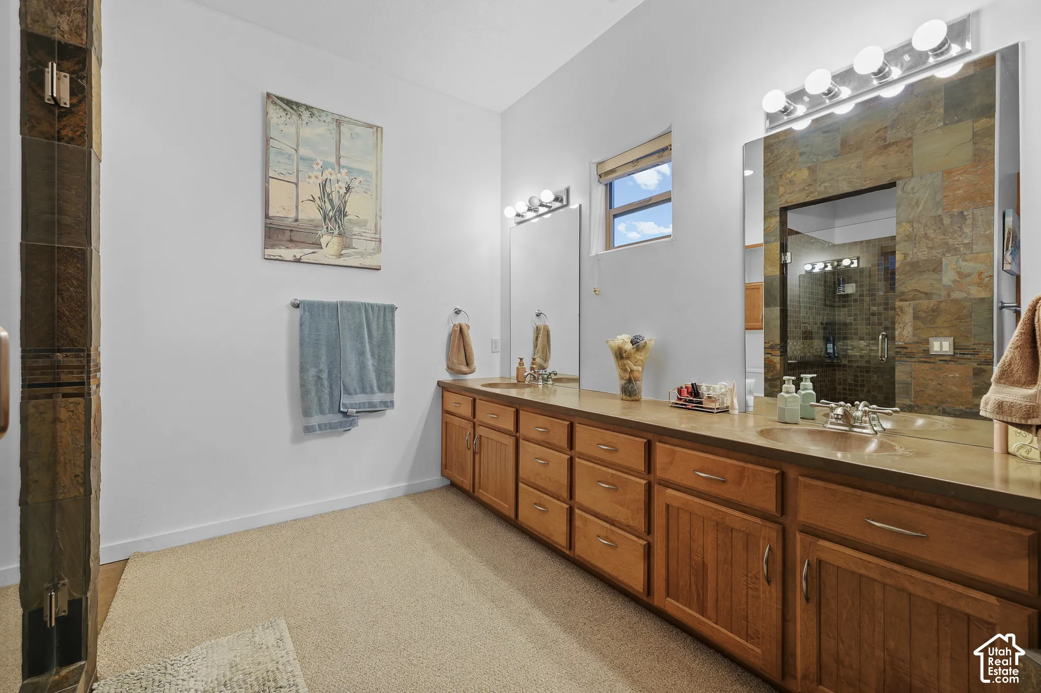 Dual vanity with individual sinks, extensive wood cabinetry, and integrated mirrors