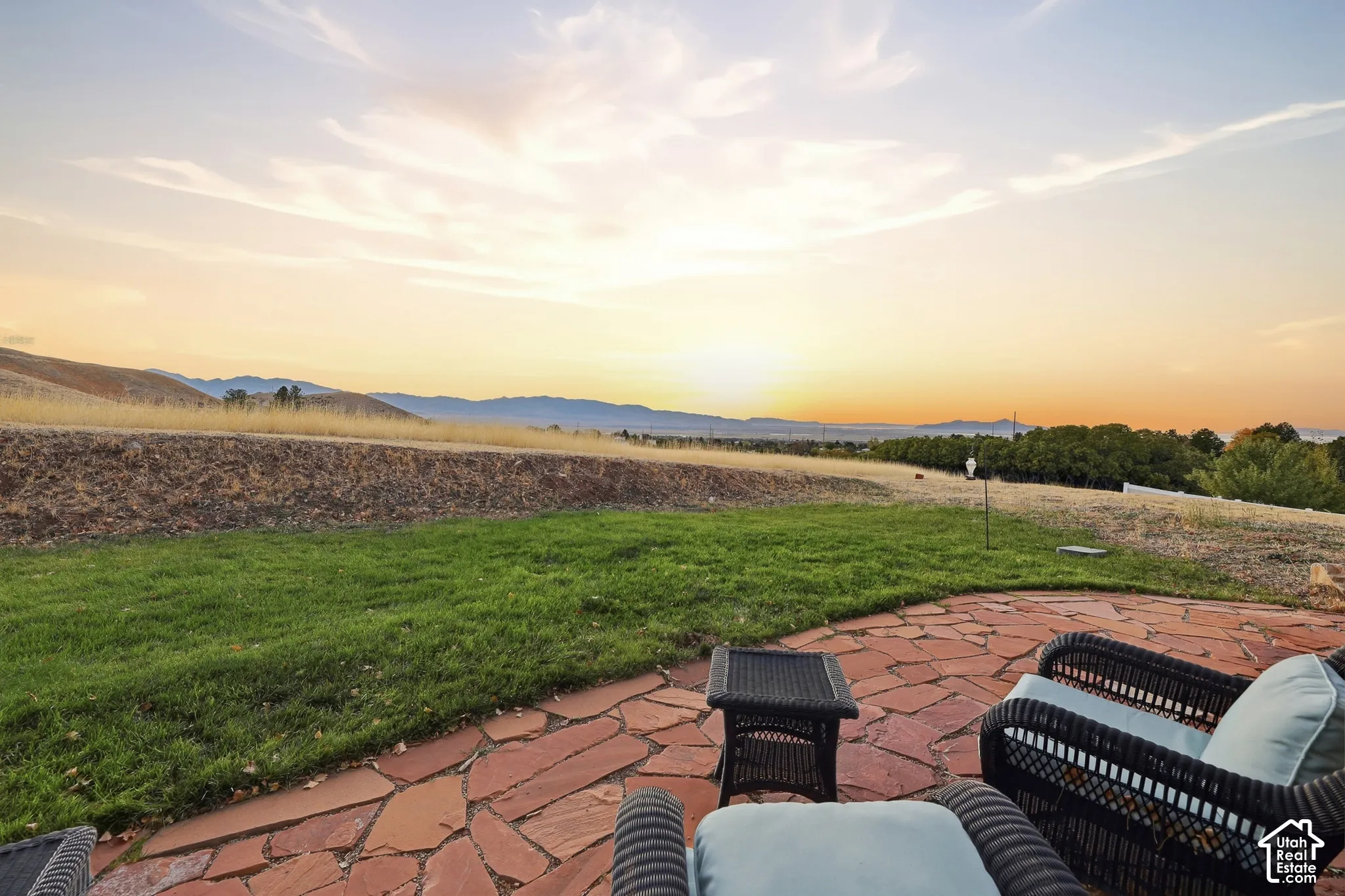Expansive patio with flagstone paving and a grass lawn