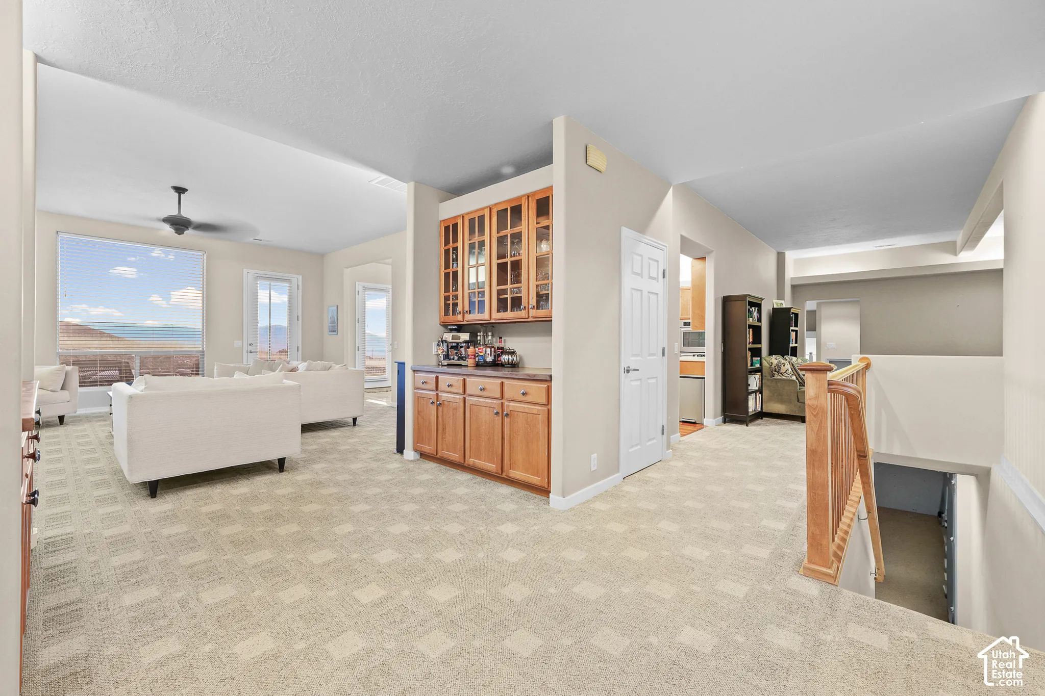 Built-in wet bar with wood cabinetry and glass-front upper cabinets