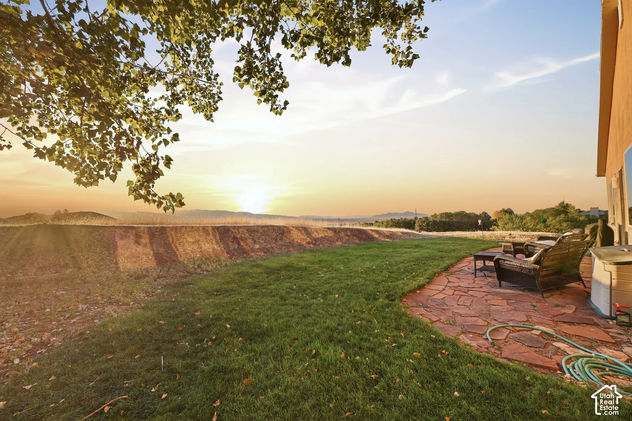 Expansive green lawn with a flagstone patio