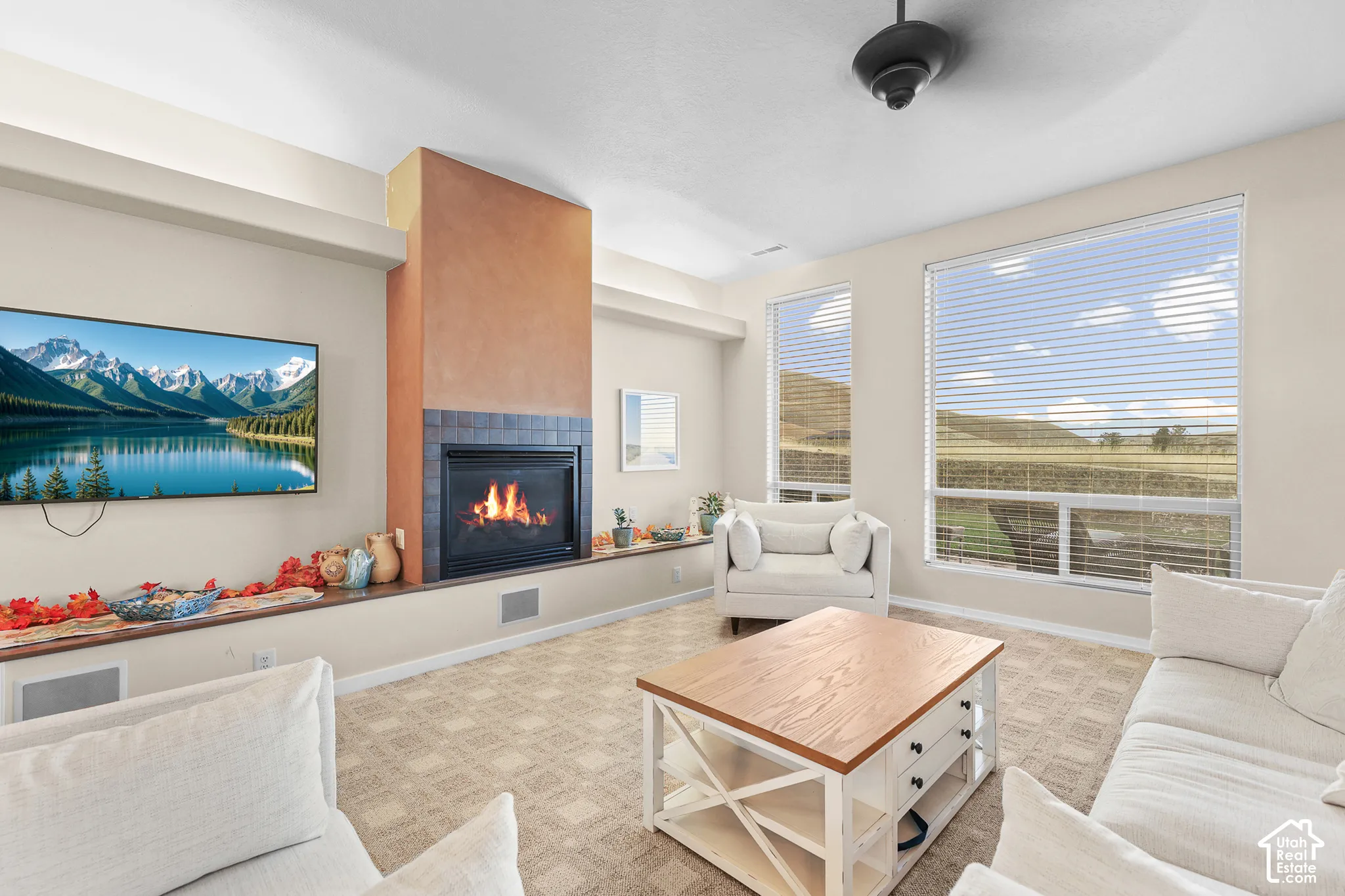 Living area with a built-in fireplace featuring a tiled hearth and stucco-textured surround