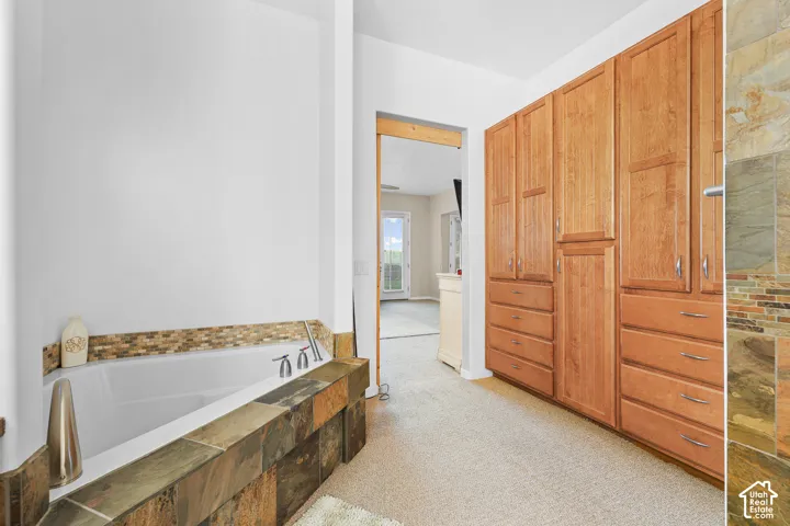 Soaking tub with mosaic tile surround and deck-mounted fixtures