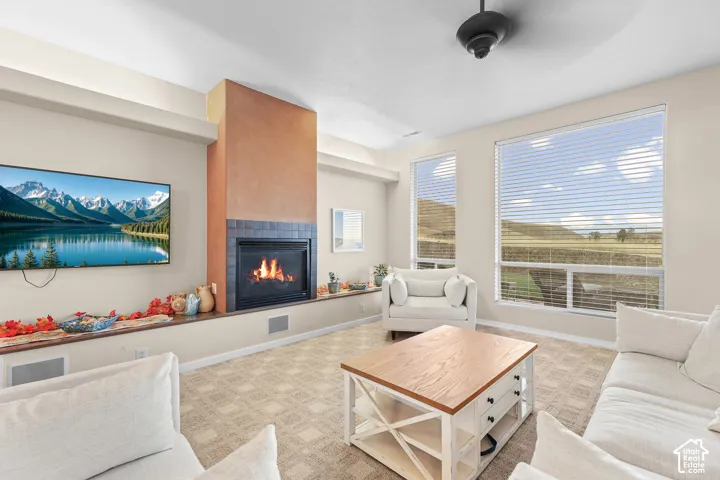 Living area with a built-in fireplace featuring a tiled hearth and stucco-textured surround