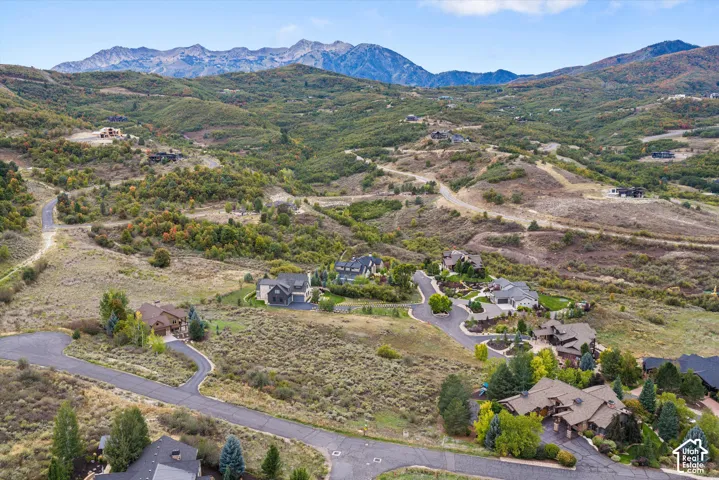 Mountainous terrain with natural vegetation, residential developments, and paved roadways