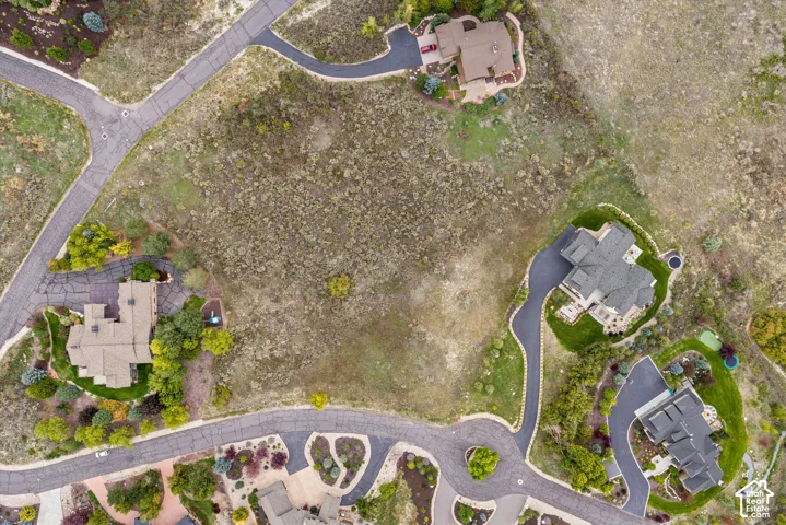 Expansive undeveloped lot with surrounding residential properties and paved access roads