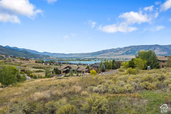 Expansive mountainous scenery featuring a large body of water and distant residential developments
