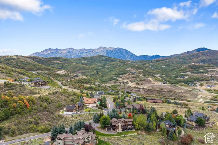 Expansive mountainous landscape featuring scattered residential properties, mature trees, and varying topography