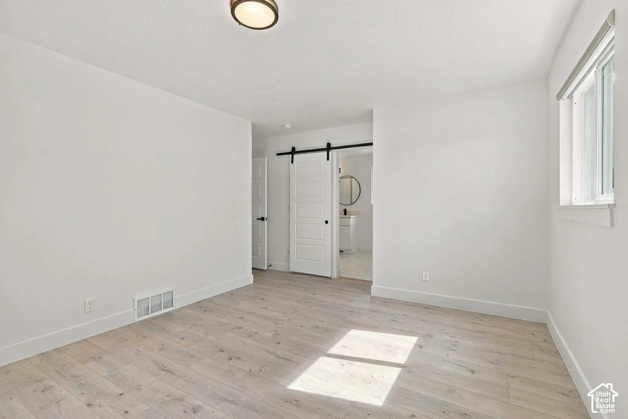 Barn door leads you to your large primary suite bathroom.
