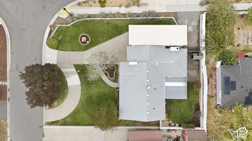 Expansive lot featuring a main residence with a gray shingle roof, a detached carport, a concrete driveway, and mature trees
